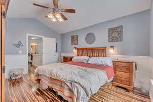 Bedroom with ceiling fan, ensuite bathroom, and vaulted ceiling