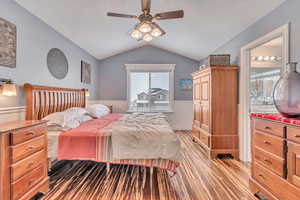 Bedroom with lofted ceiling, a textured ceiling, and ceiling fan