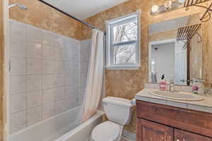 Full bathroom featuring vanity, toilet, and shower / tub combo with curtain