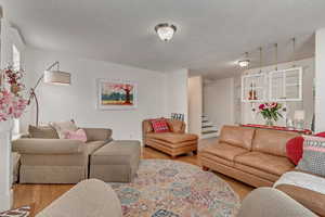 Living room with light hardwood / wood-style floors and a textured ceiling