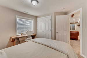 Carpeted bedroom featuring a closet and a textured ceiling