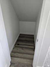 Stairs featuring vaulted ceiling and hardwood / wood-style floors