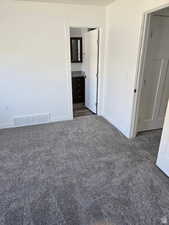 Spare room featuring dark colored carpet