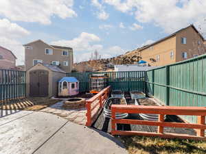 View of patio / terrace featuring a fire pit and a storage unit