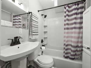 Bathroom featuring shower / bath combination with curtain and toilet