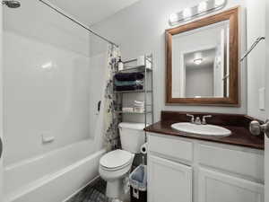 Full bathroom with shower / tub combo, vanity, and toilet