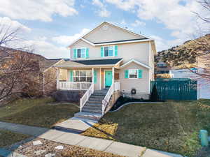 View of front of house featuring a front lawn and covered porch