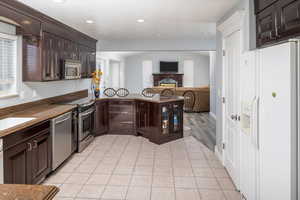 Kitchen with appliances with stainless steel finishes, sink, and dark brown cabinets