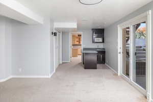 Kitchen featuring a kitchen island, sink, and light colored carpet