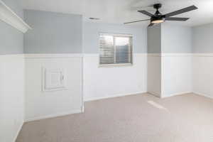 Carpeted bedroom featuring ceiling fan