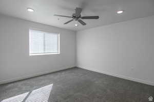 Empty room with dark colored carpet and ceiling fan