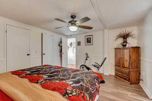 Bedroom featuring a textured ceiling, light hardwood / wood-style flooring, and ceiling fan