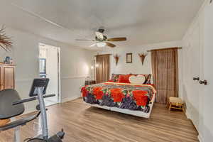 Bedroom featuring a textured ceiling, light hardwood / wood-style flooring, and ceiling fan