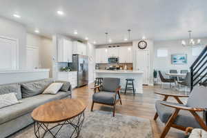 Living room with an inviting chandelier and light hardwood / wood-style floors