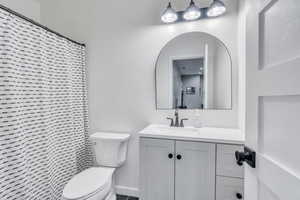 Bathroom featuring vanity, toilet, and a shower with shower curtain