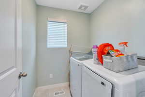 Laundry room featuring independent washer and dryer and light tile patterned floors