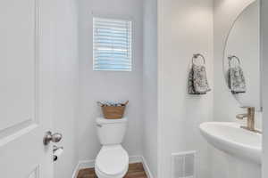 Bathroom featuring sink, hardwood / wood-style floors, and toilet