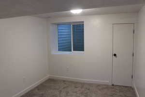 Unfurnished room with light colored carpet and a textured ceiling