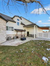 Back of house with central air condition unit, a patio, and a lawn