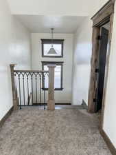 Foyer featuring dark colored carpet