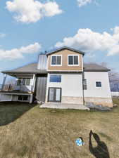 Rear view of house with a patio, a yard, and french doors