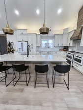 Kitchen with hanging light fixtures, backsplash, and a large island with sink