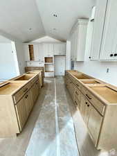 Kitchen with a center island, vaulted ceiling, and a textured ceiling