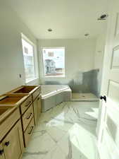 Bathroom with vanity and a tub to relax in