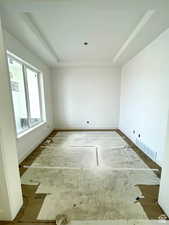 Empty room with a raised ceiling and wood-type flooring