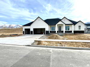 Modern farmhouse featuring a garage and a mountain view