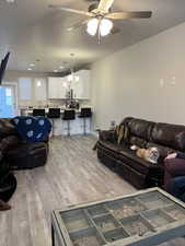 Living room featuring a textured ceiling, light hardwood / wood-style floors, and ceiling fan