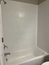 Bathroom with toilet and tiled shower / bath