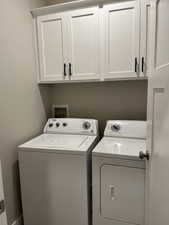 Laundry area featuring washer and clothes dryer and cabinets