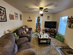 Carpeted living room with ceiling fan