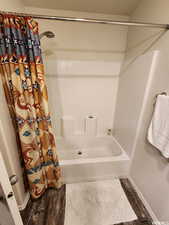 Bathroom featuring shower / bathtub combination with curtain and wood-type flooring