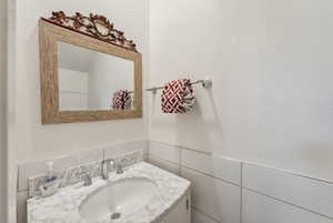 Bathroom with vanity and tile walls