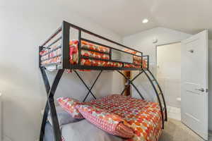 Bedroom with lofted ceiling and carpet floors