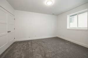 Unfurnished room with dark colored carpet