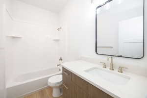 Full bathroom featuring vanity, shower / bathing tub combination, hardwood / wood-style floors, and toilet