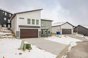 View of front of house with central AC unit and a garage