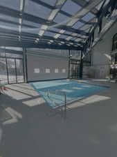 Community pool with a patio and glass enclosure