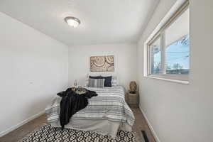 Carpeted bedroom with a textured ceiling