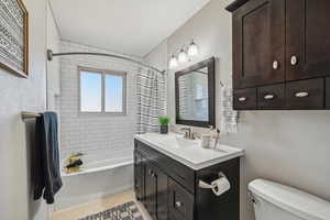 Full bathroom with vanity, tile patterned flooring, toilet, and shower / bath combo with shower curtain