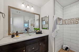 Bathroom with vanity and tiled shower