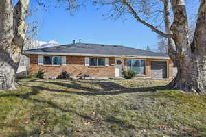 Front view of house featuring a garage and a lawn