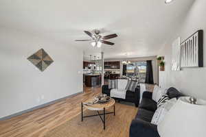 Living room featuring ceiling fan and light hardwood / wood-style floors