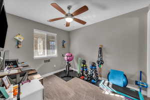 Workout room featuring ceiling fan and carpet flooring