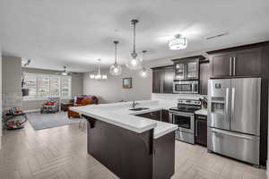 Kitchen featuring a kitchen bar, sink, hanging light fixtures, appliances with stainless steel finishes, and kitchen peninsula