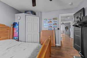 Bedroom with ceiling fan, dark hardwood / wood-style flooring, a closet, and a textured ceiling