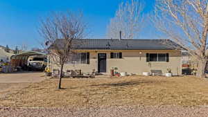 Ranch-style house with a carport and a front lawn